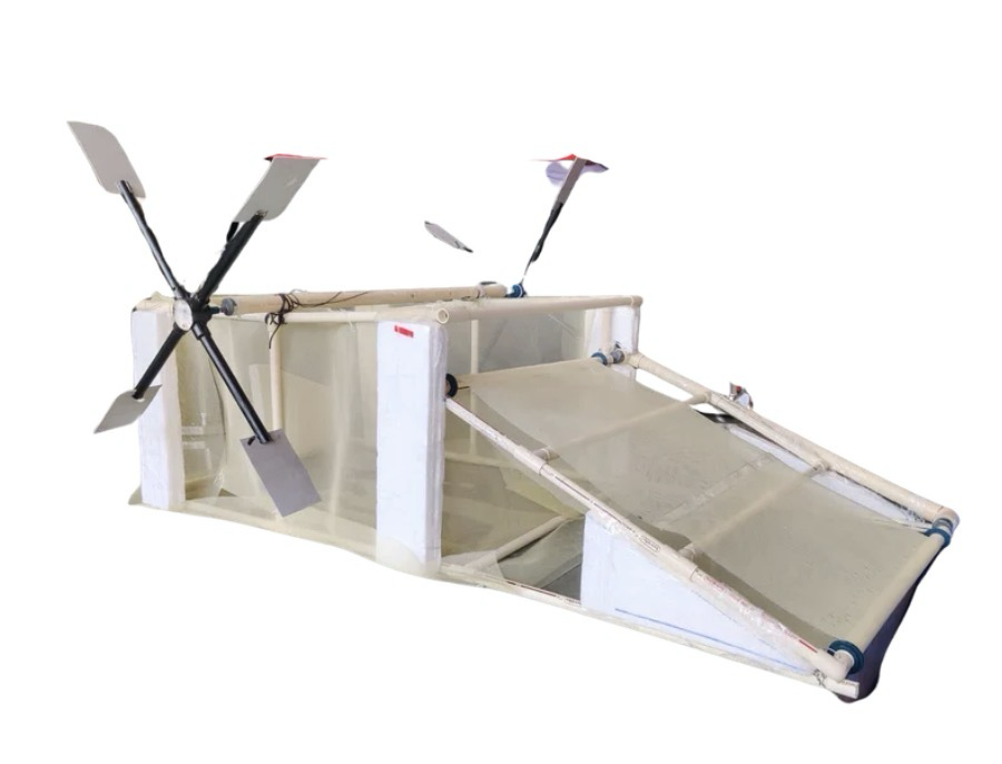 The Lake Sentry V1 prototype: a white CPVC pipe frame on thermocol floats, with a slanted mesh conveyor ramp at the front and two paddle wheels at the back.